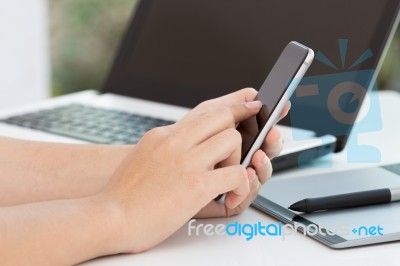 Hand Touch On Black Phone On Desk Stock Photo