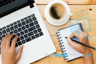 Hand Using Laptop And Write Note Inspire Idea On Wood Desk Stock Photo