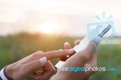 Hand Using Phone Outdoor At Sunset Stock Photo