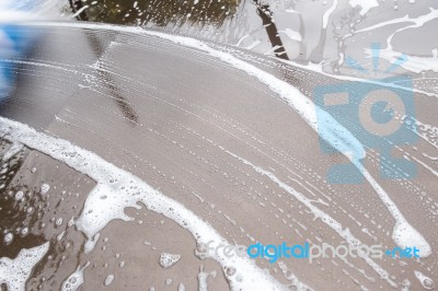 Hand Washing Brown Car With Blue Sponge And Bubbles Stock Photo