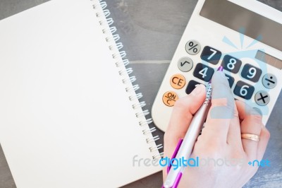 Hand With Calculator And Notepad Stock Photo