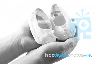 Hands Holding Baby Shoes Stock Photo