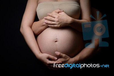 Hands Of Pregnant Woman And Her Husband On Belly Stock Photo