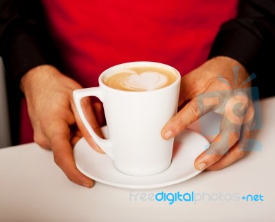 Hands Of Waiter Serving A Cup Of Cappucino Stock Photo