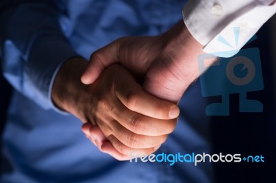 Handshake Handshaking In Dark With Low Light Stock Photo