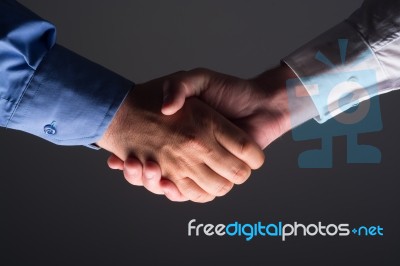 Handshake Handshaking In Dark With Low Light Stock Photo