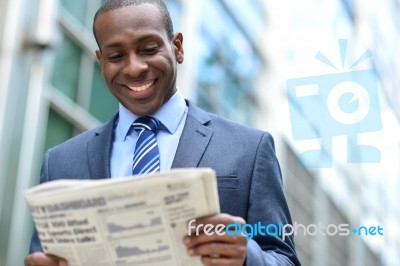 Handsome African Man Reading A Newspaper Stock Photo