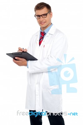 Handsome Doctor Writing Prescription Stock Photo