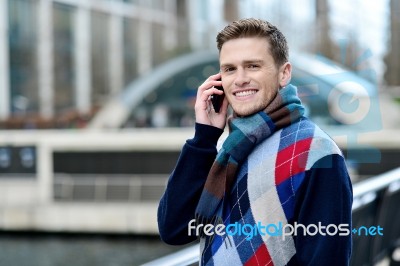 Handsome Man Using Mobile At Bridge Railing Stock Photo