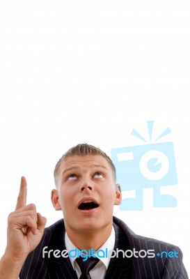 Handsome Young Executive Pointing And Looking Upwards Stock Photo