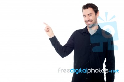 Handsome Young Guy Pointing At Something Stock Photo