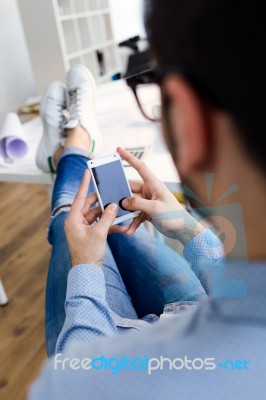 Handsome Young Man Using His Mobile Phone In The Office Stock Photo