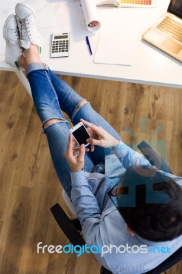 Handsome Young Man Using His Mobile Phone In The Office Stock Photo