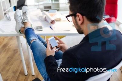 Handsome Young Man Using His Mobile Phone In The Office Stock Photo