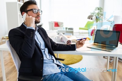 Handsome Young Man Using His Mobile Phone In The Office Stock Photo