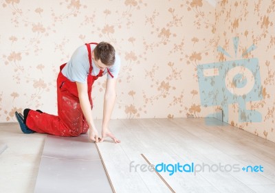 Handyman Laying Down Laminate Flooring Boards Stock Photo