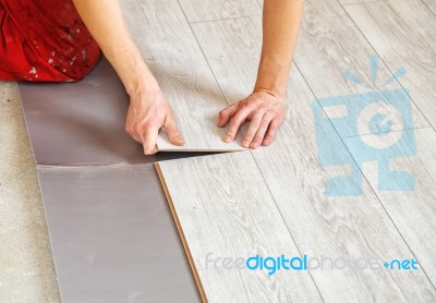 Handyman's Hands Laying Down Laminate Flooring Boards Stock Photo