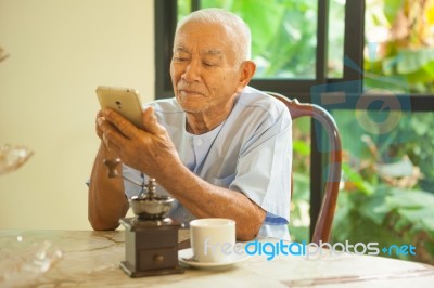 Happy Asian Senior Man Using The Mobile Phone In Home Stock Photo