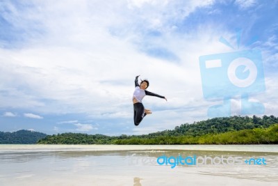 Happy Asian Woman Jumping Fun On The Beach Stock Photo