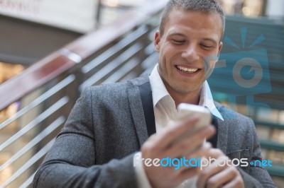 Happy Businessman With Smartphone In Business Building Stock Photo