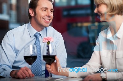 Happy Couple Drinking Red Wine At A Restaurant Stock Photo