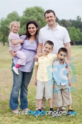 Happy Couple With Divine Kids Looking At You Stock Photo