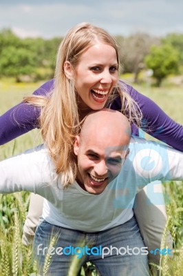 Happy Cute Woman Being Piggy Backed By Her Boyfriend Stock Photo