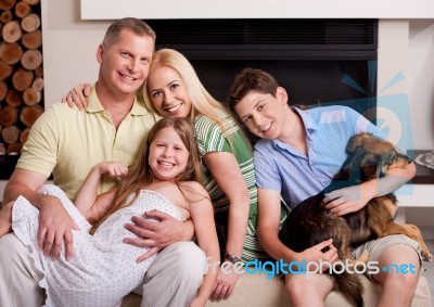 Happy Domestic Family Sitting In Living Room With Dog Stock Photo