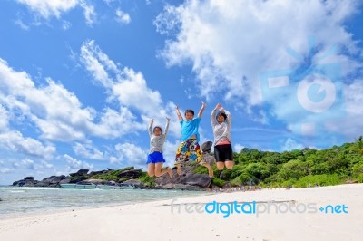 Happy Family Jumping On Beach In Thailand Stock Photo