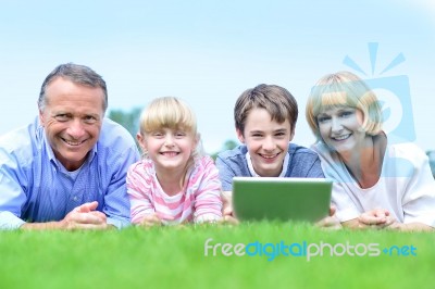 Happy Family Lying On The Grass In Park Stock Photo