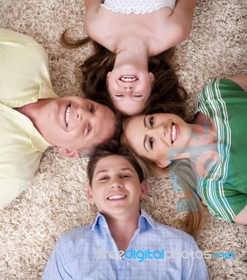 Happy Family Lying  With Their Heads Close Together Smiling Stock Photo