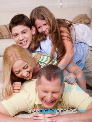 Happy Family Of Four Having Fun In Bed Stock Photo