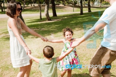 Happy Family Of Four In Park Stock Photo