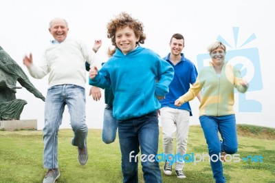 Happy Family Running At The Lawn Stock Photo