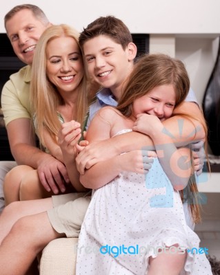 Happy Family Sitting In Straight And Having Fun Stock Photo