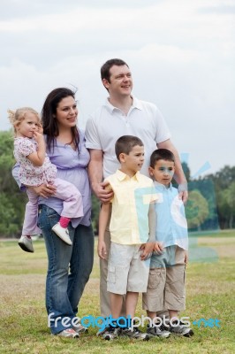 Happy Family With Three Kids Looking Away With Curiosity Stock Photo