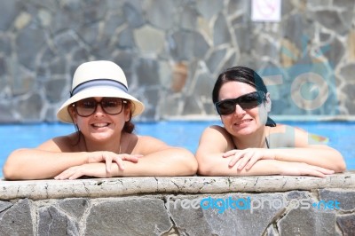 Happy Friends In The Pool. Focus In The Right Lady Stock Photo