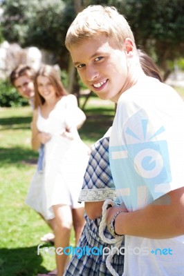 Happy Friends Pulling A Rope Against Each Other Stock Photo