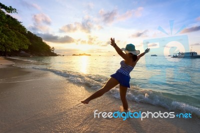 Happy Girl On The Beach At Sunrise Stock Photo