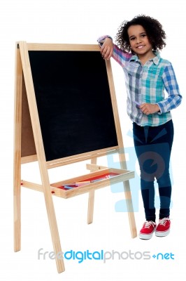 Happy Girl Resting Her Hand On Blackboard Stock Photo