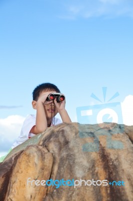 Happy Little Boy Exploring Outdoors Clambering On A Rock With Te… Stock Photo