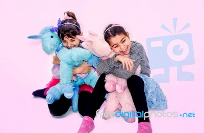 Happy Little Girls Holding  Unicorn Toys  Isolated On Pink Stock Photo