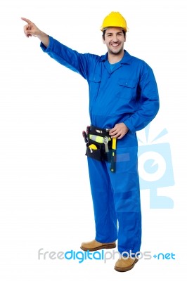 Happy Male Worker Pointing At Something Stock Photo