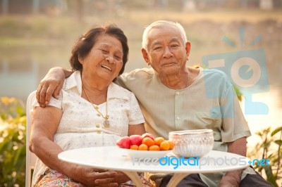 Happy Senior Couple Sitting Outdoors Stock Photo