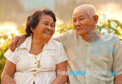 Happy Senior Couple Sitting Outdoors Stock Photo