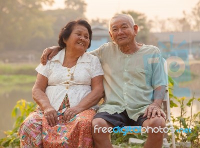 Happy Senior Couple Sitting Outdoors Stock Photo