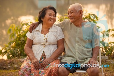 Happy Senior Couple Sitting Outdoors Stock Photo