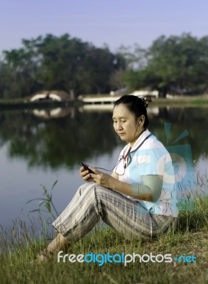 Happy Woman On Grass Listening To Music Stock Photo