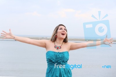 Happy Woman With Open Arms Looking At The Sky Stock Photo