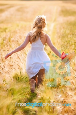 Happy Young Blonde Girl In White Dress With Straw Hat Running Th… Stock Photo